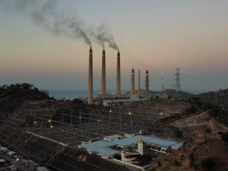 Smoke ash spews from the chimney of a coal power plant owned by Indonesian Power