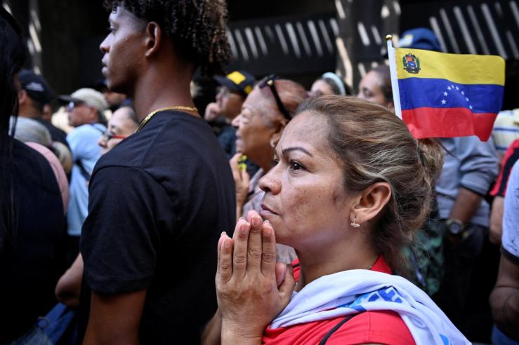 Venezuelans march outside the National Assembly as vice president and oil minister, Delcy Rodriguez, was formally sworn in as the country’s interim president