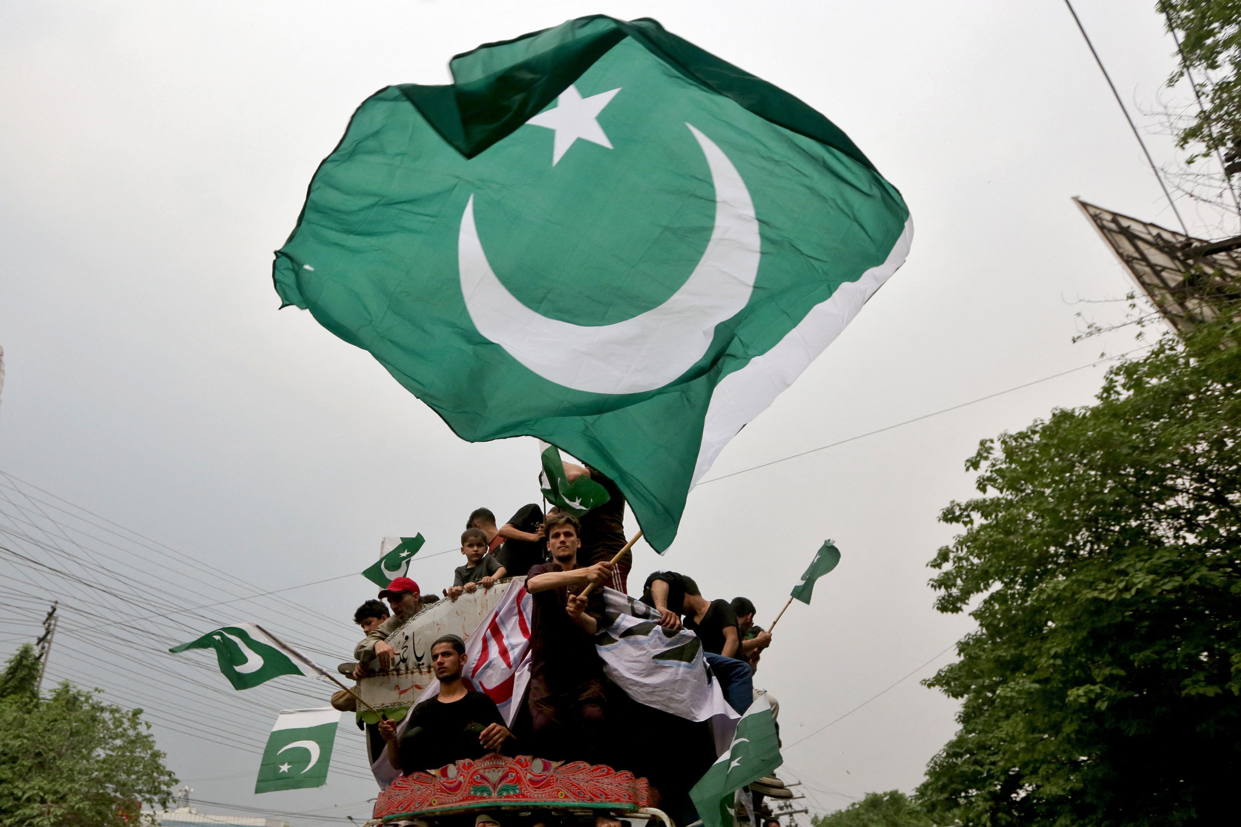People wave flags as they rally in support of Pakistan Army.