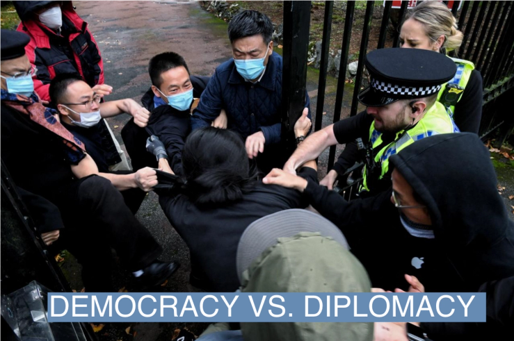 A man is pulled at the gate of the Chinese consulate after a demonstration against China’s President Xi Jinping, in Manchester on October 16, 2022.