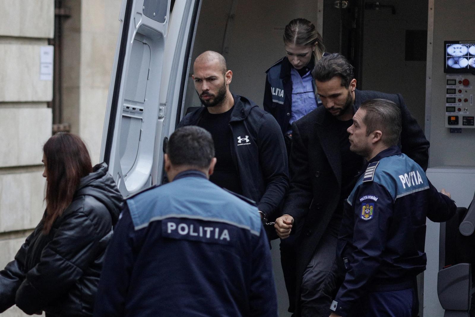 Andrew Tate and his brother Tristan are escorted by police officers outside the headquarters of the Bucharest Court of Appeal, in Bucharest, Romania, January 10, 2023.