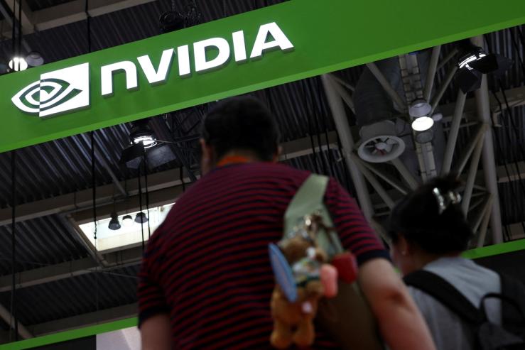 People stand near the Nvidia logo at its booth during the China International Supply Chain Expo in Beijing