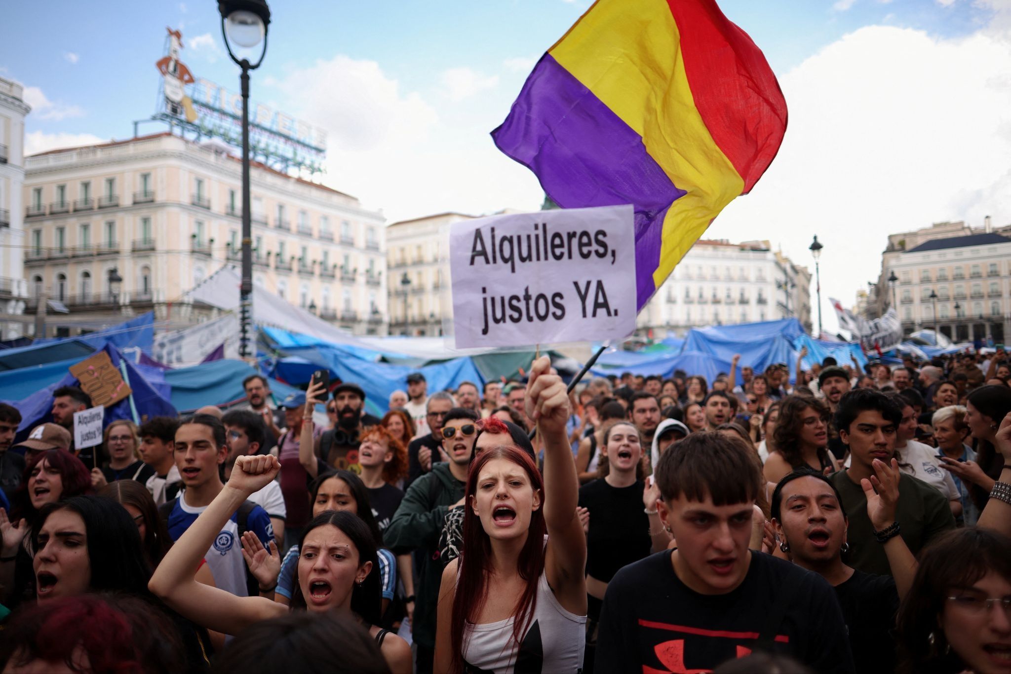 A woman holds a placard in a protest in Madrid that says ‘Fair rents now!’ 
