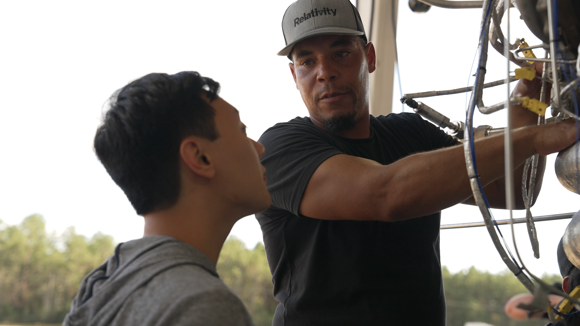 Senior technician Robert Caldwell shows engineer Kenrick Chan a new method for securing the gas generator to the engine