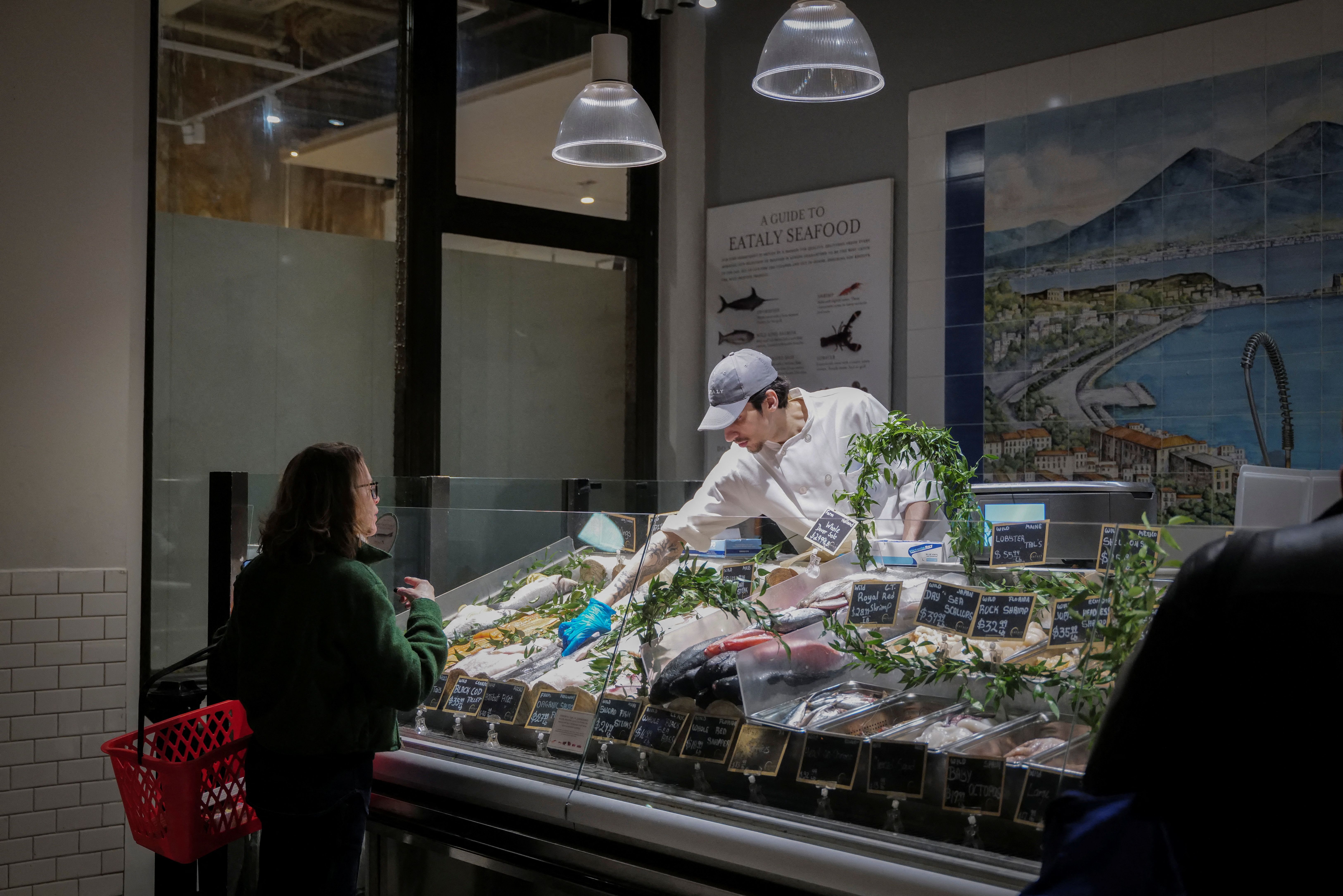 A woman shops a fish at a store in New York City.