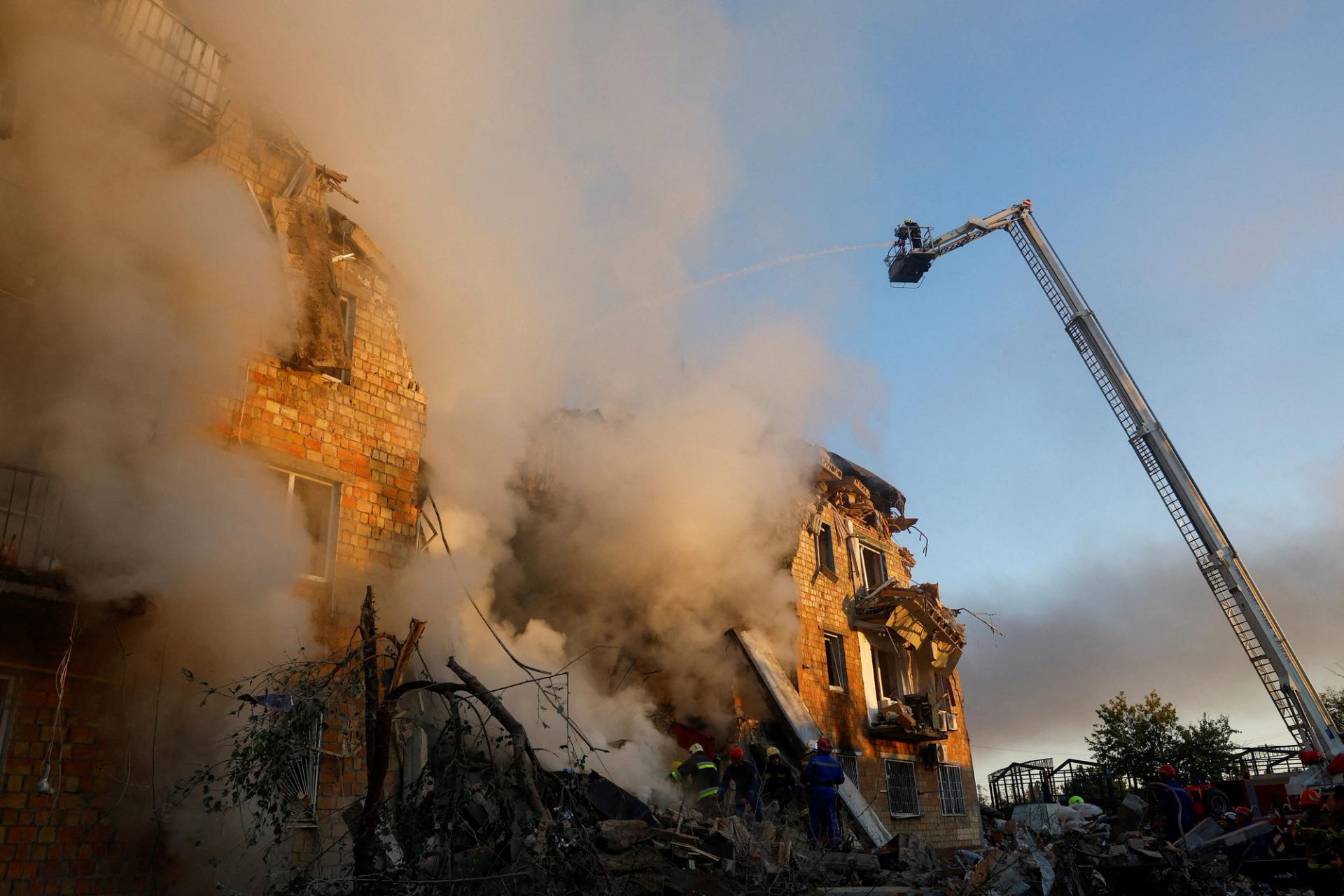 escuers work at the site of a building in Kyiv which was hit by Russian missile and drone strikes