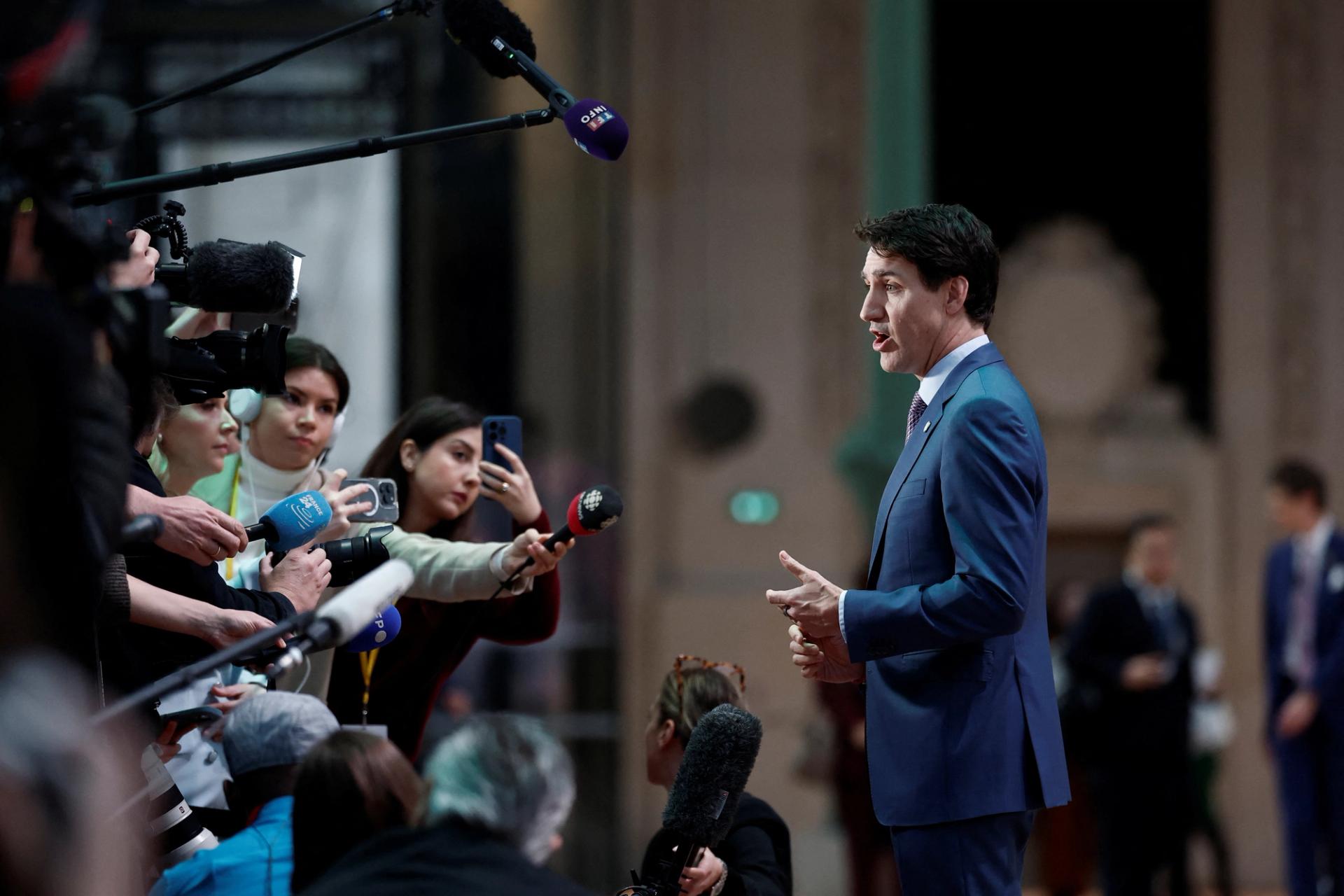 Canadian Prime Minister Justin Trudeau talks to journalists as he arrives to attend the Artificial Intelligence (AI) Action Summit.