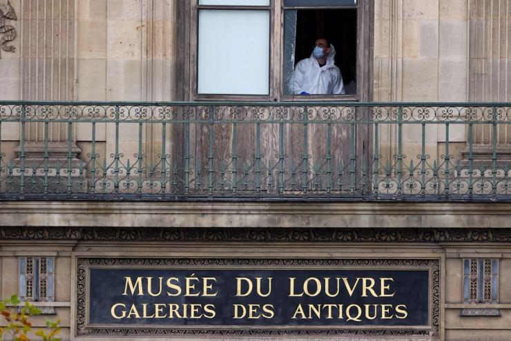 A member of a forensic team inspects a window believed to have been used in what the French Interior Ministry said was a robbery at the Louvre museum during which jewellery was stolen, in Paris, France, October 19, 2025