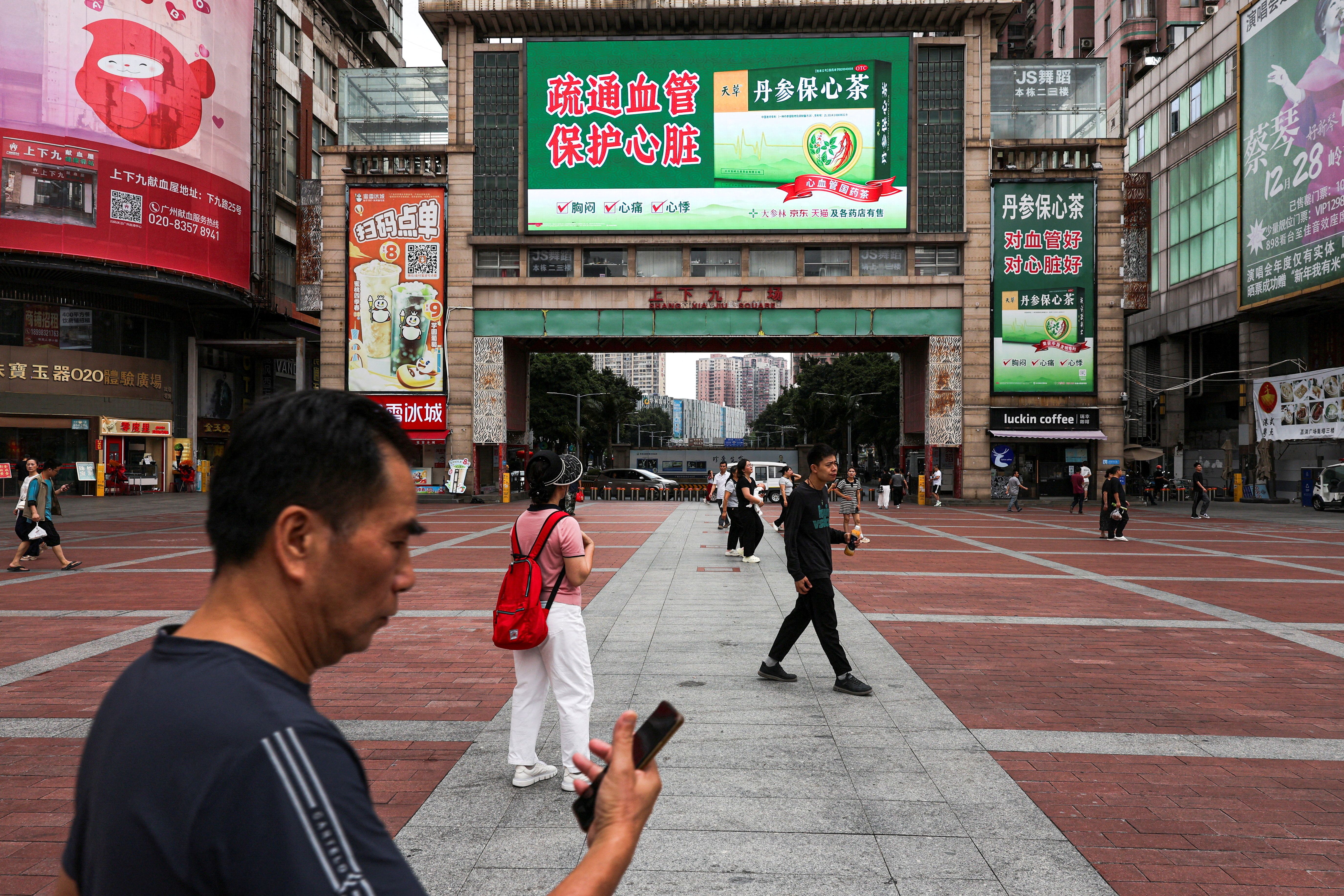 People walk in a square in Guangzhou, Guangdong province.