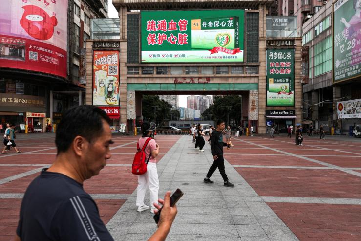 People walk in a square in Guangzhou, Guangdong province.
