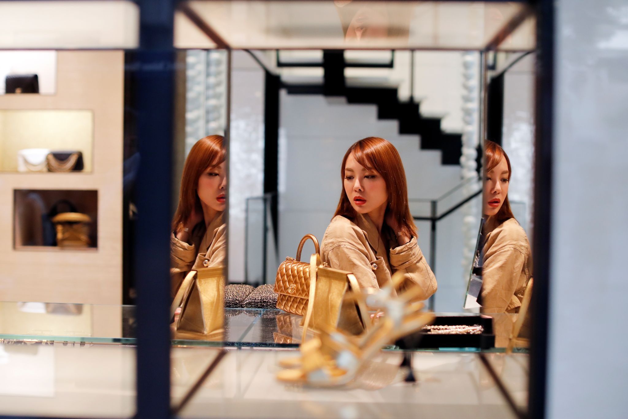 A woman looks at a luxury shop window in China. 