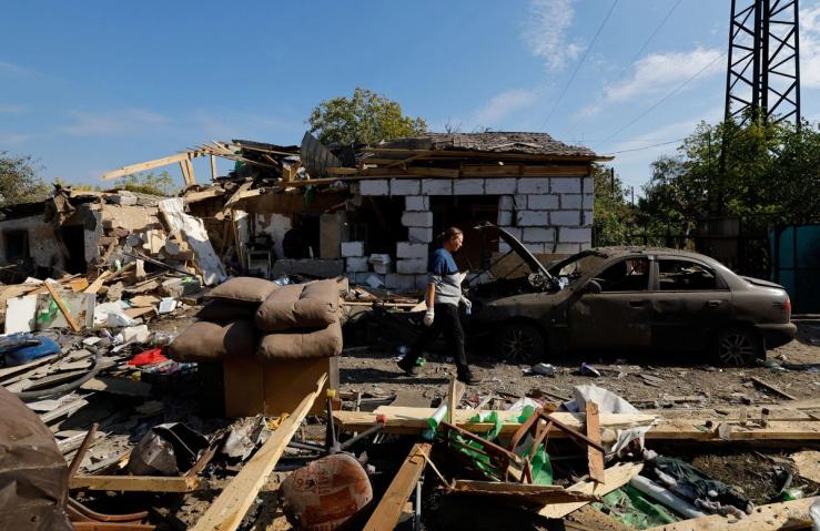 A woman walks past her house, which was destroyed by what Russian-installed authorities called a recent Ukraine drone attack in Donetsk, a Russian controlled city of Ukraine.