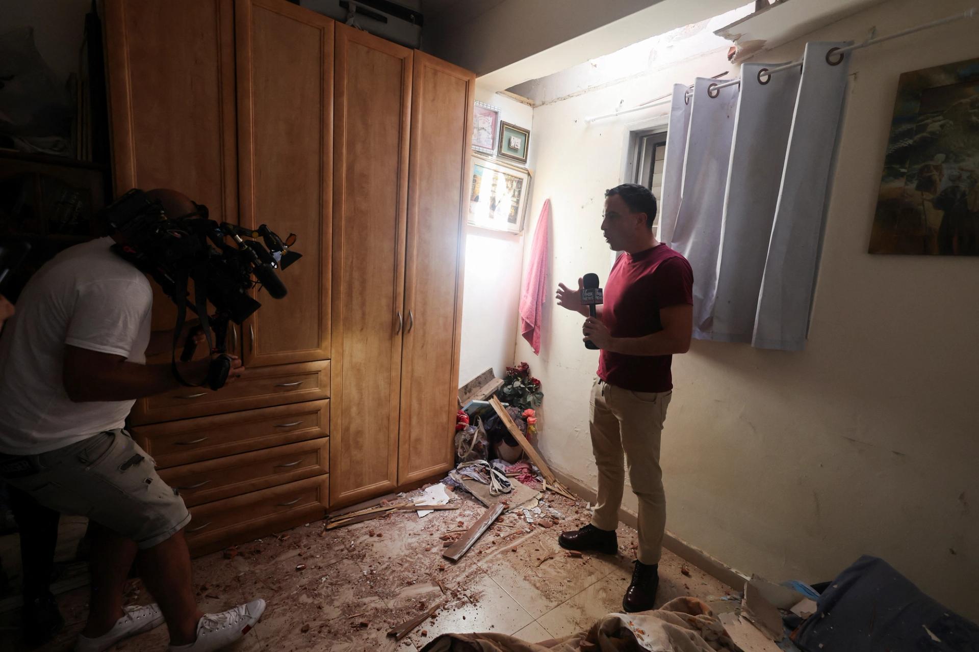 A media person reports from inside a house damaged after rockets were fired from the Gaza Strip towards Israel.
