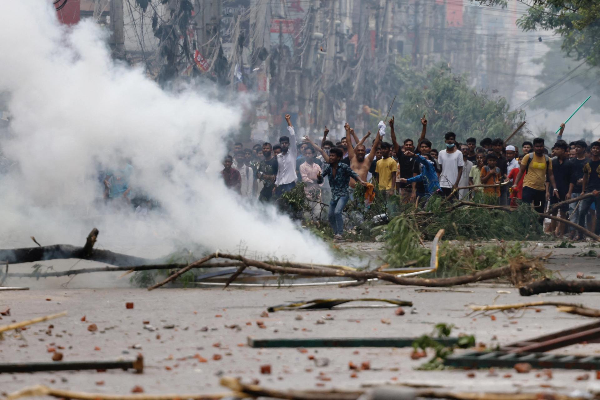 FILE PHOTO: People gesture near smoke as protesters clash with Border Guard Bangladesh (BGB) and the police outside the state-owned Bangladesh Television as violence erupts across the country after anti-quota protests by students, in Dhaka, Bangladesh, July 19, 2024. REUTERS/Mohammad Ponir Hossain/File Photo