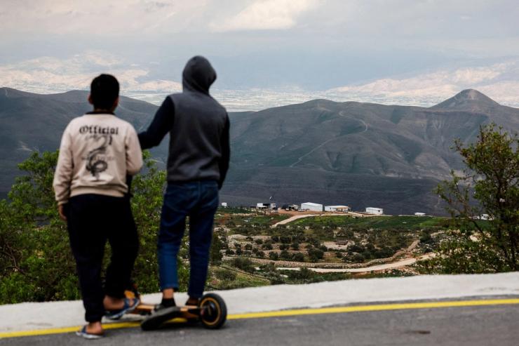 Palestinian children look at new Israeli settlement.