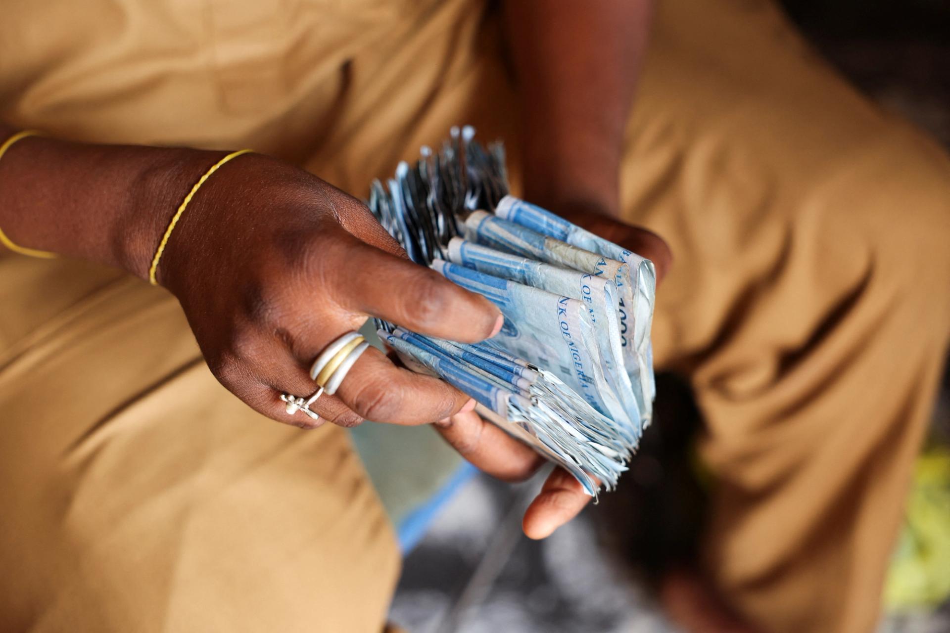 A person counts Nigerian naira notes in a market place.