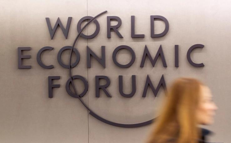 A woman walks past the logo of the World Economic Forum (WEF) 2023 at Davos Congress Centre in the Alpine resort of Davos, Switzerland, January 15, 2023.