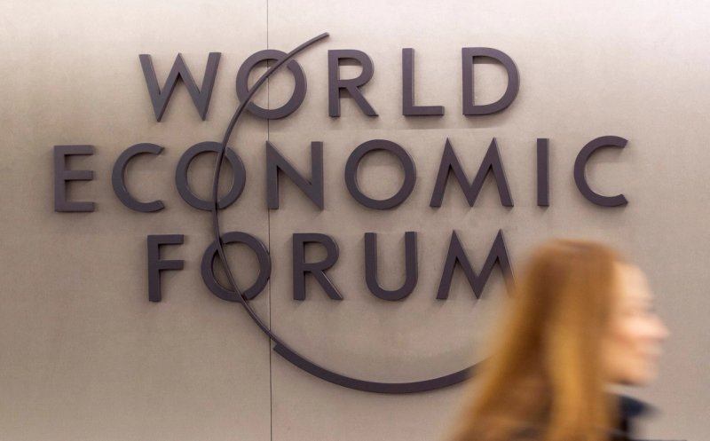 A woman walks past the logo of the World Economic Forum (WEF) 2023 at Davos Congress Centre in the Alpine resort of Davos, Switzerland, January 15, 2023. 