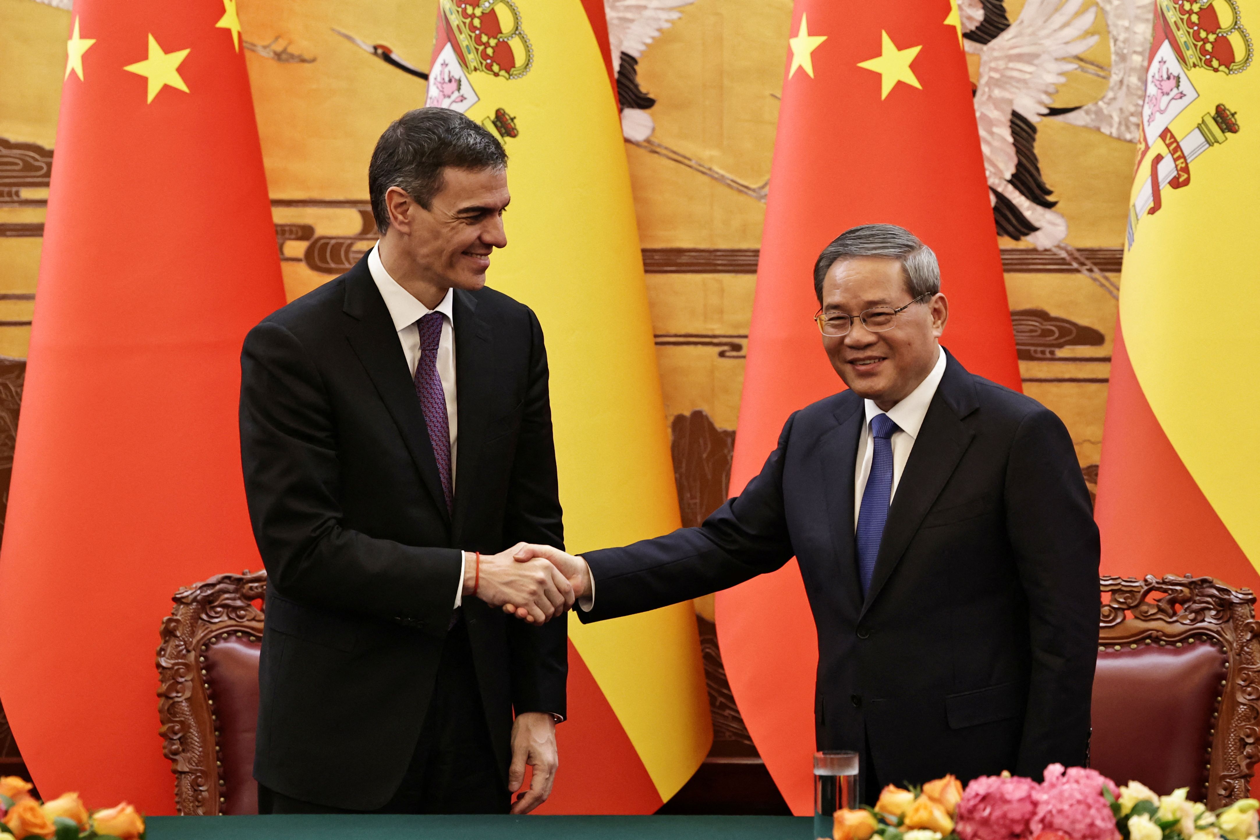 Spanish Prime Minister Pedro Sanchez and Chinese Premier Li Qiang shake hands after a signing ceremony at the Great Hall of the People in Beijing