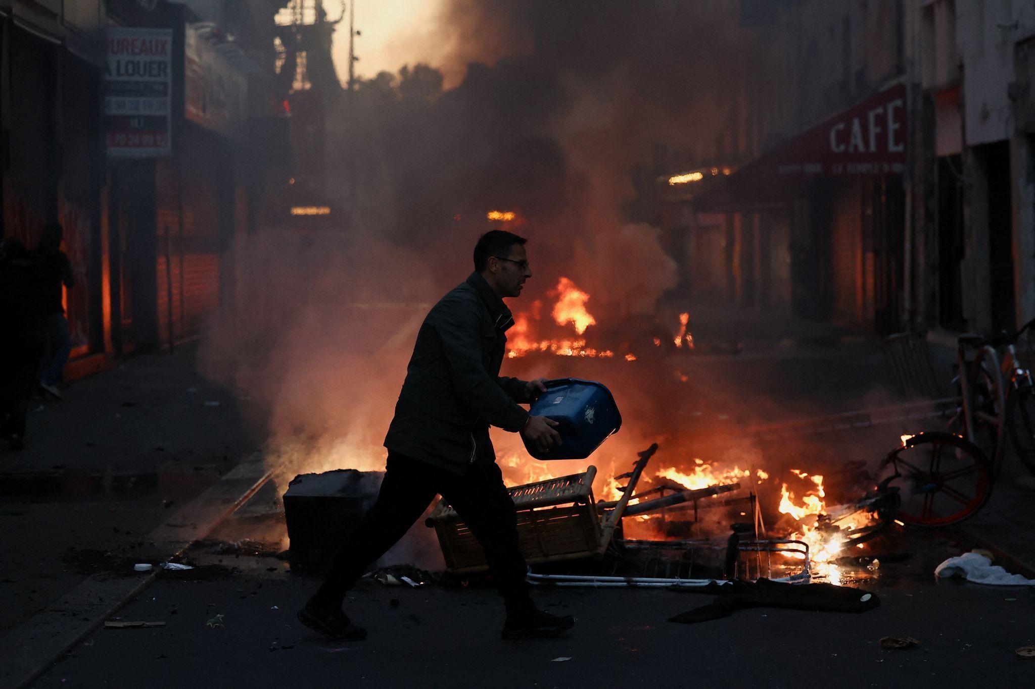 A man tries to extinguish a fire after a day of national demonstrations in Paris.