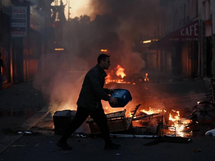 A man tries to extinguish a fire after a day of national demonstrations in Paris.