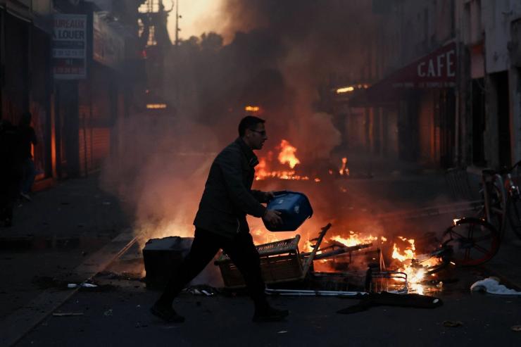 A man tries to extinguish a fire after a day of national demonstrations in Paris.