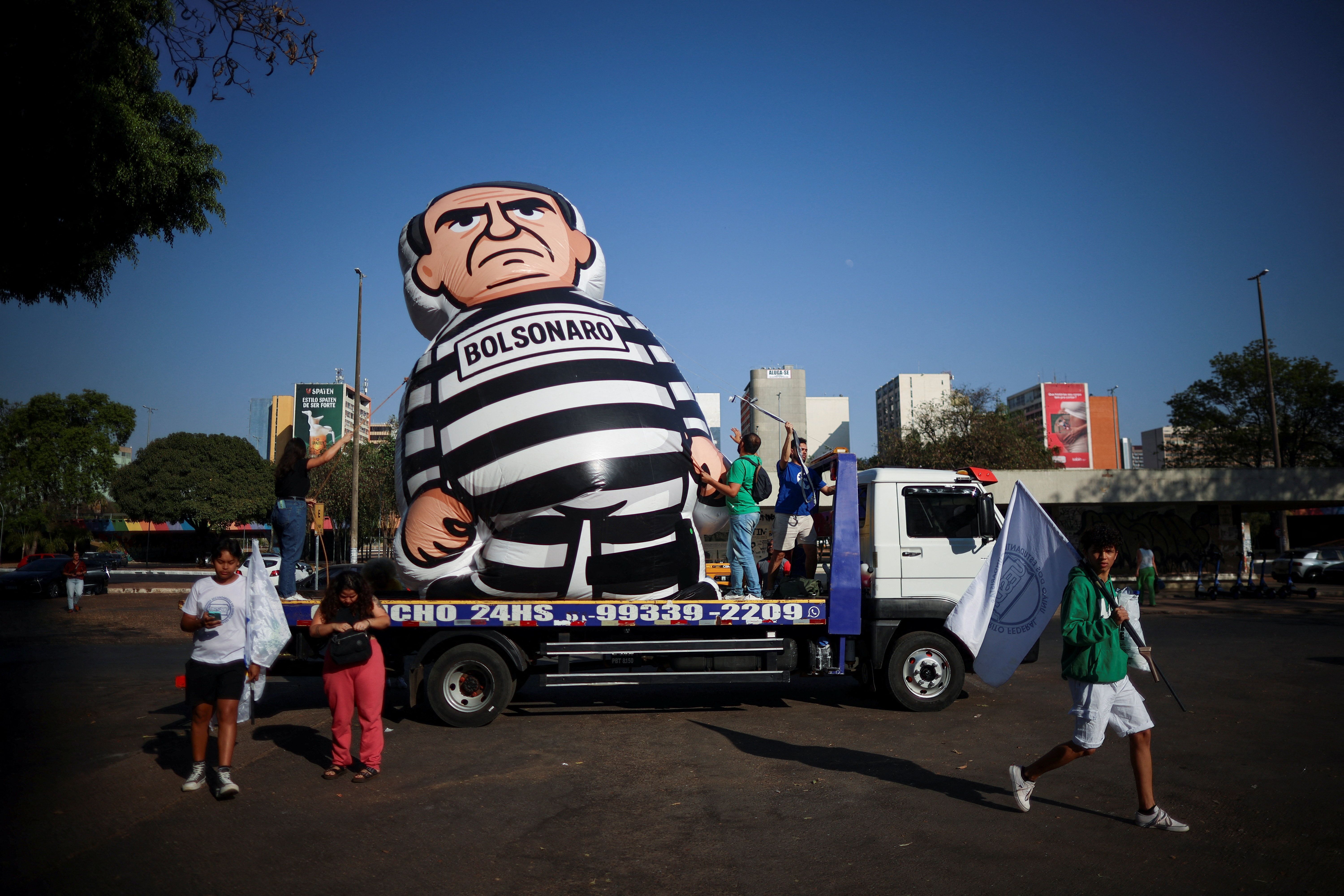 Demonstrators inflate a doll depicting former Brazilian President Jair Bolsonaro.
