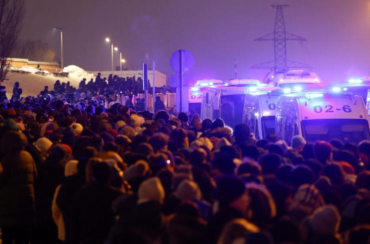 Law enforcement officers stand guard as people queue to enter the Borisovskoye cemetery and visit the grave of Russian opposition politician Alexei Navalny following his funeral in Moscow, on March 1.