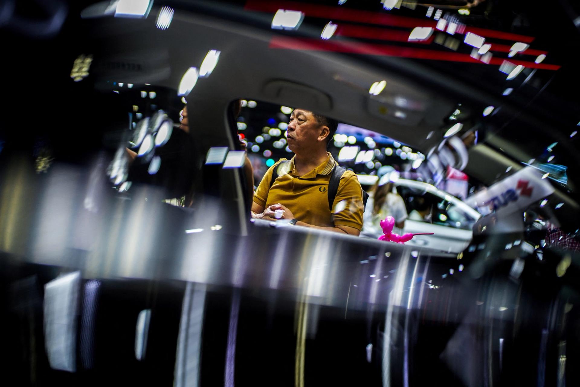 A visitor stands next to a BYD Seal EV car at the 41st Thailand International Motor Expo, in Bangkok, Thailand