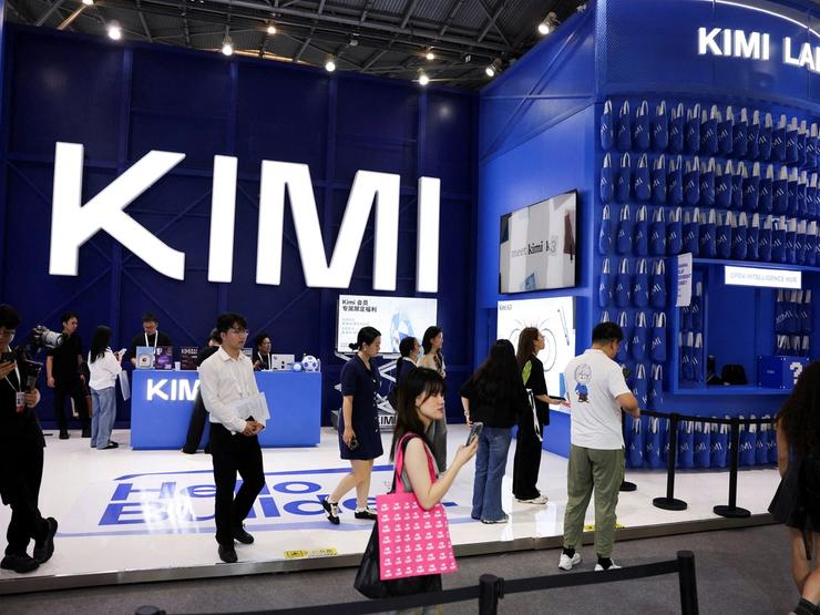 People walk past the Moonshot booth promoting its Kimi K3 AI model