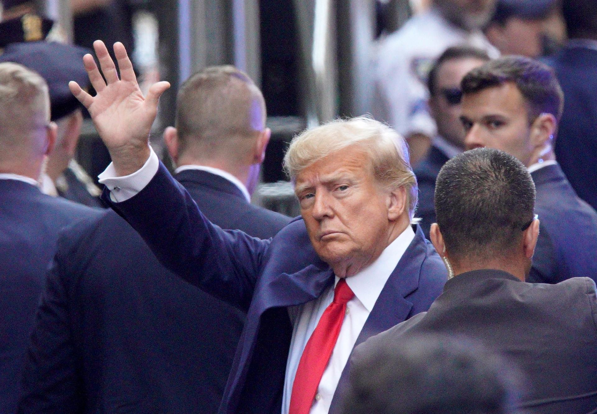 Trump waves to supporters before turning himself 