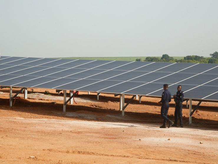 Security forces members walk past solar panels at the Ferke Solar photovoltaic power plant in Côte d’Ivoire.