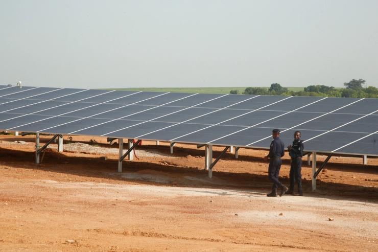 Security forces members walk past solar panels at the Ferke Solar photovoltaic power plant in Côte d’Ivoire.