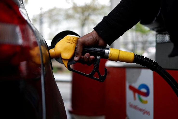 A car is filled up with petrol at a TotalEnergies gas station in Paris, France.