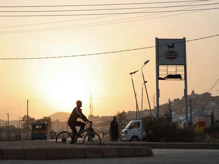 A person rides a bicycle at sunrise in Jos, Plateau State, north central Nigeria.