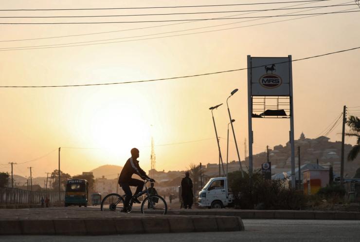 A person rides a bicycle at sunrise in Jos, Plateau State, north central Nigeria.
