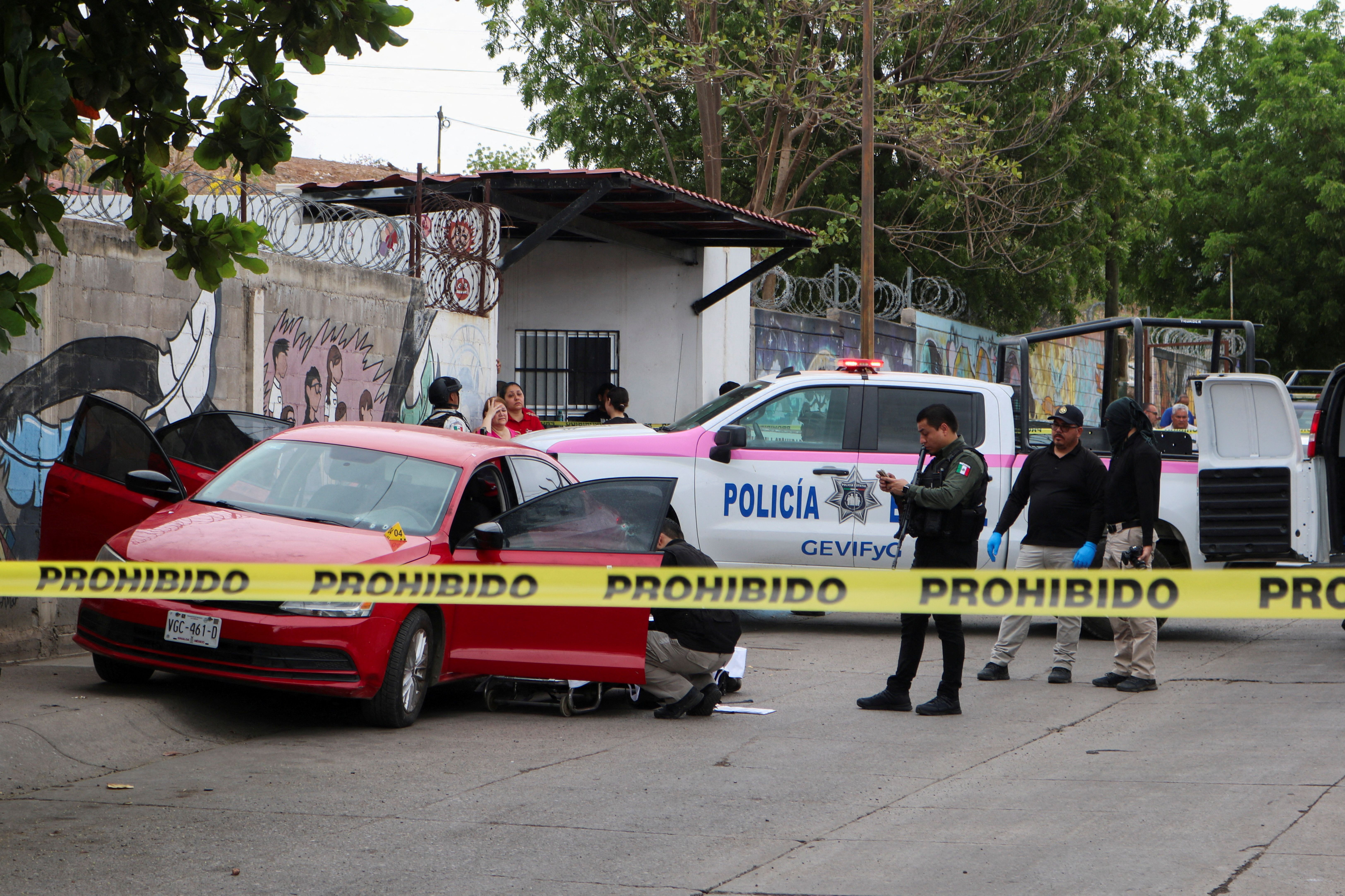Police officers work in a crime scene where a man was gunned down in Sinaloa state, Mexico.