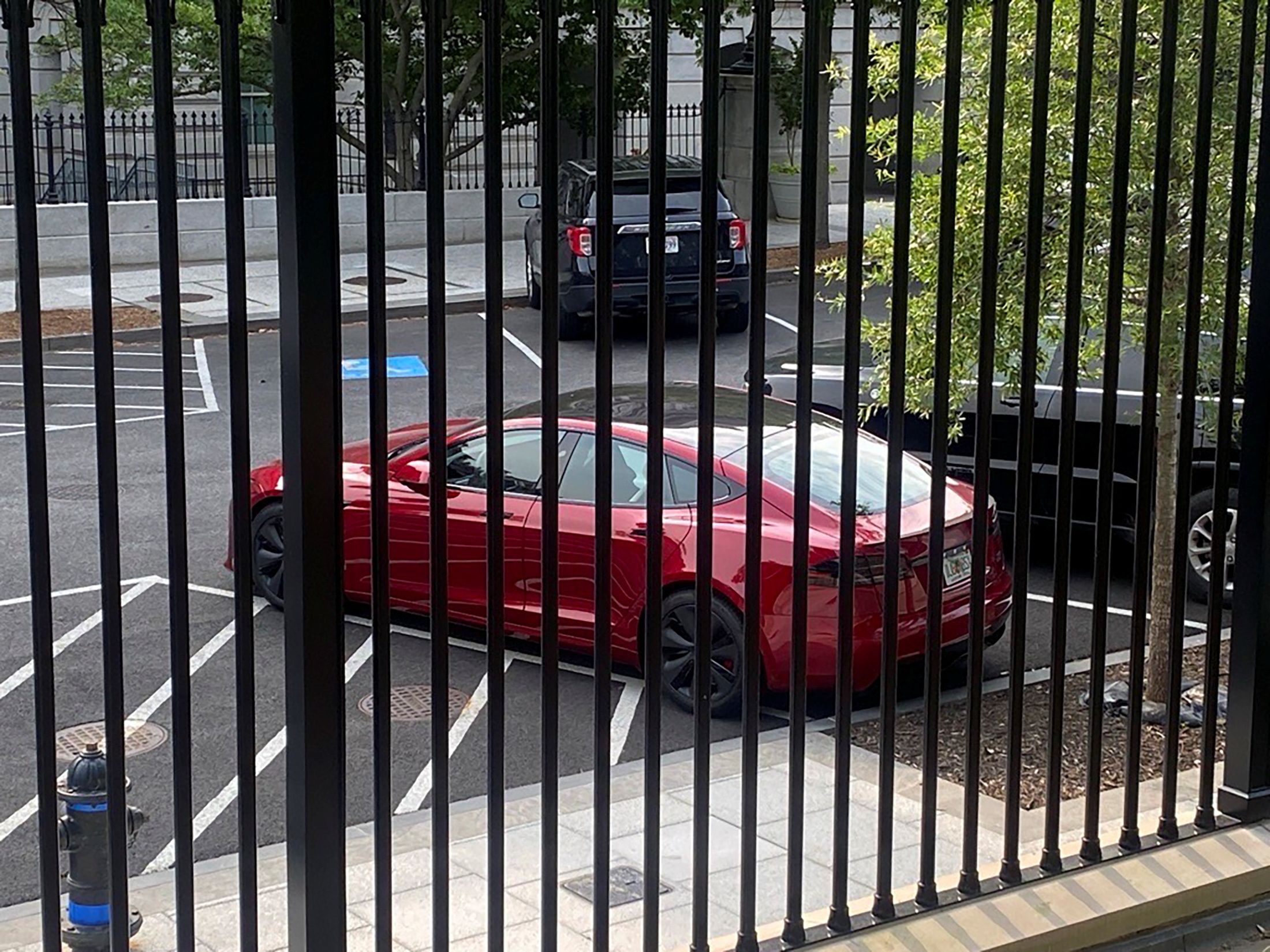 A Tesla car as seen behind a gate.