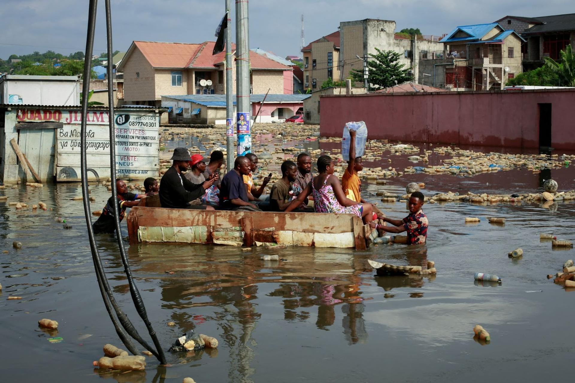 People use a makeshift boat to move after the River Congo rises to its highest level, causing flooding in Kinshasa, Democratic Republic of Congo.