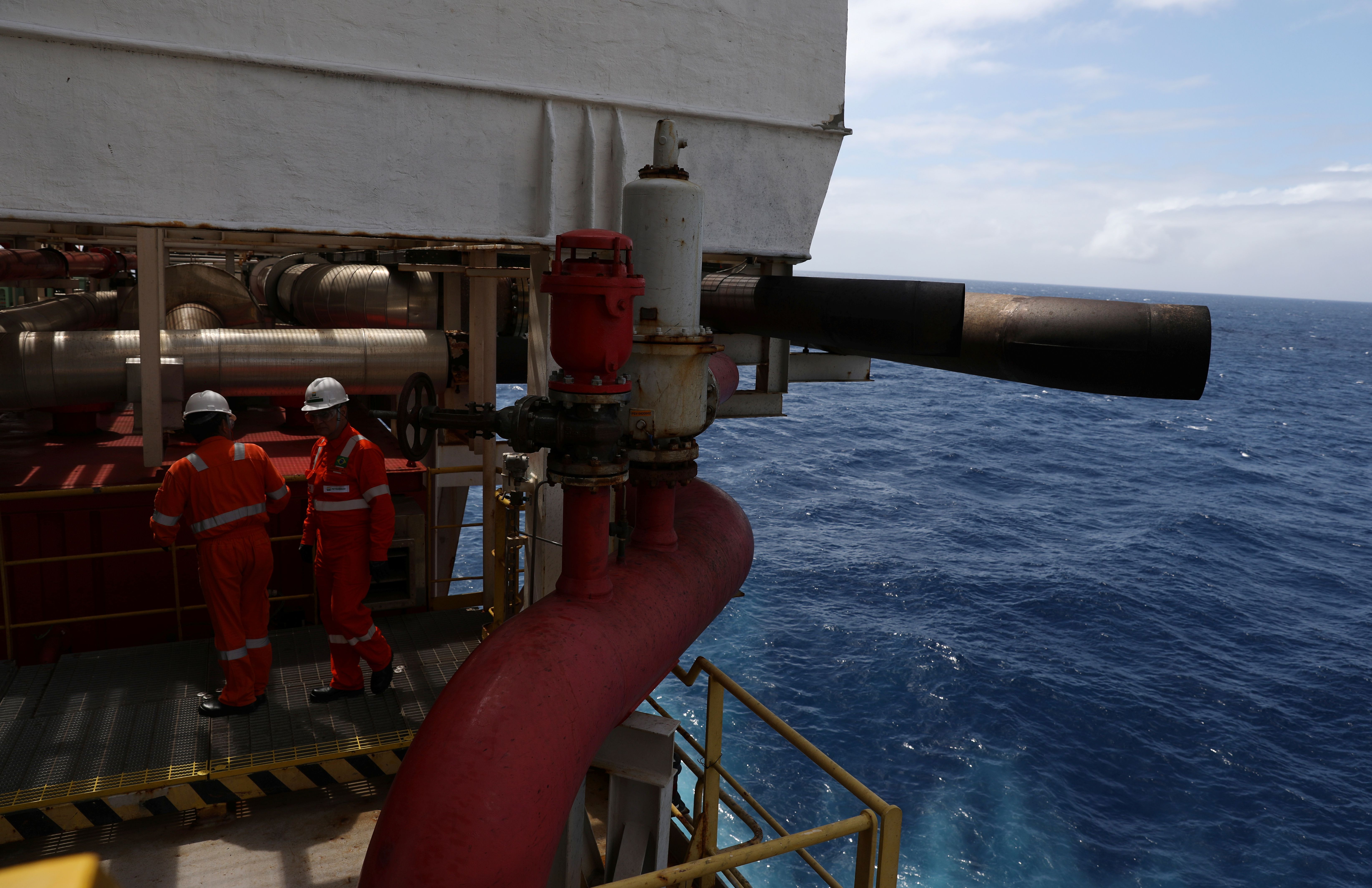 Workers inspect offshore oil rig 