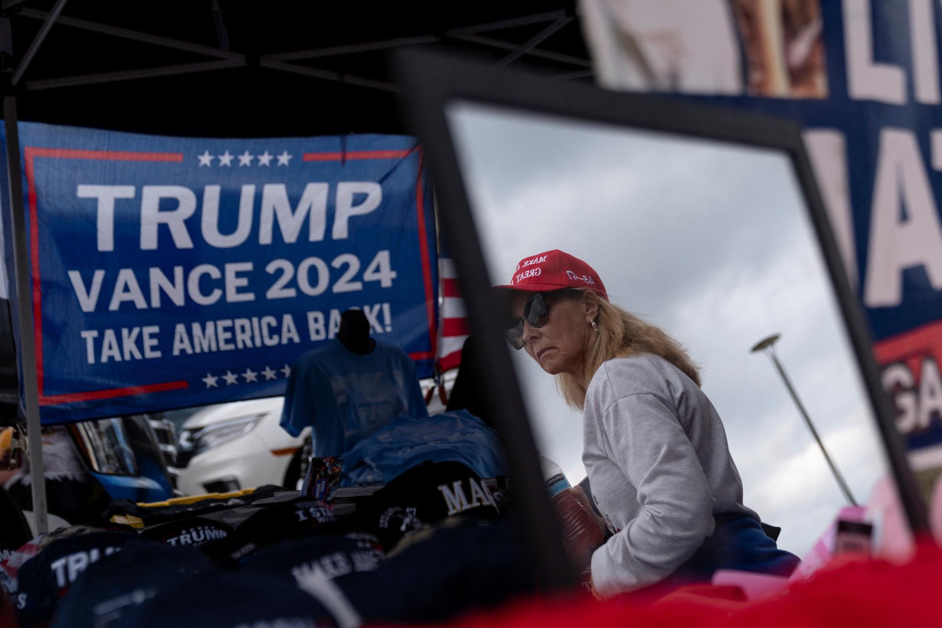 A supporter of Republican presidential nominee and former US President Donald Trump is seen in a reflection while shopping for campaign merchandise on the day of a campaign stop in Macon, Georgia U.S.,