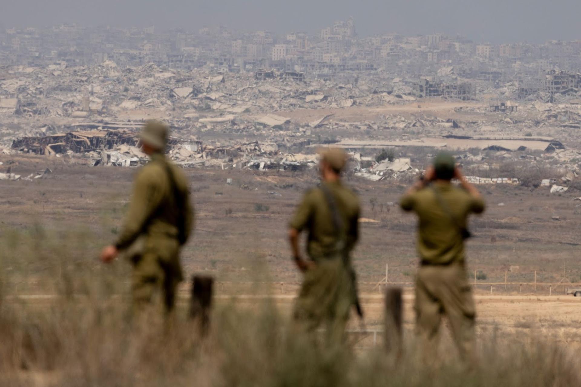  Israeli soldiers look at destroyed buildings in the Northern Gaza Strip. 