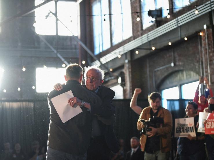 Graham Platner, Democratic candidate for U.S. Senate in Maine, hugs U.S. Senator Bernie Sanders (I-VT) after speaking during a “Fighting Oligarchy” campaign rally in Portland, Maine, U.S.,