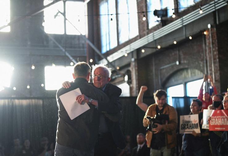 Graham Platner, Democratic candidate for U.S. Senate in Maine, hugs U.S. Senator Bernie Sanders (I-VT) after speaking during a “Fighting Oligarchy” campaign rally in Portland, Maine, U.S.,