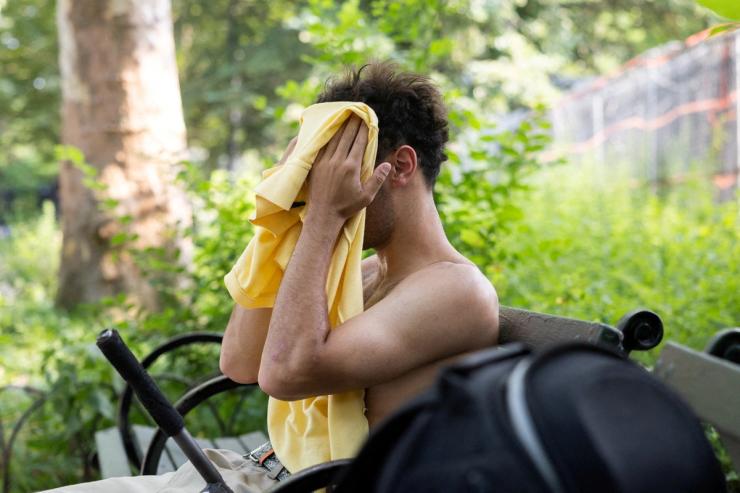 A man wipes his face amid a heatwave at Brower Skate Park in New York City