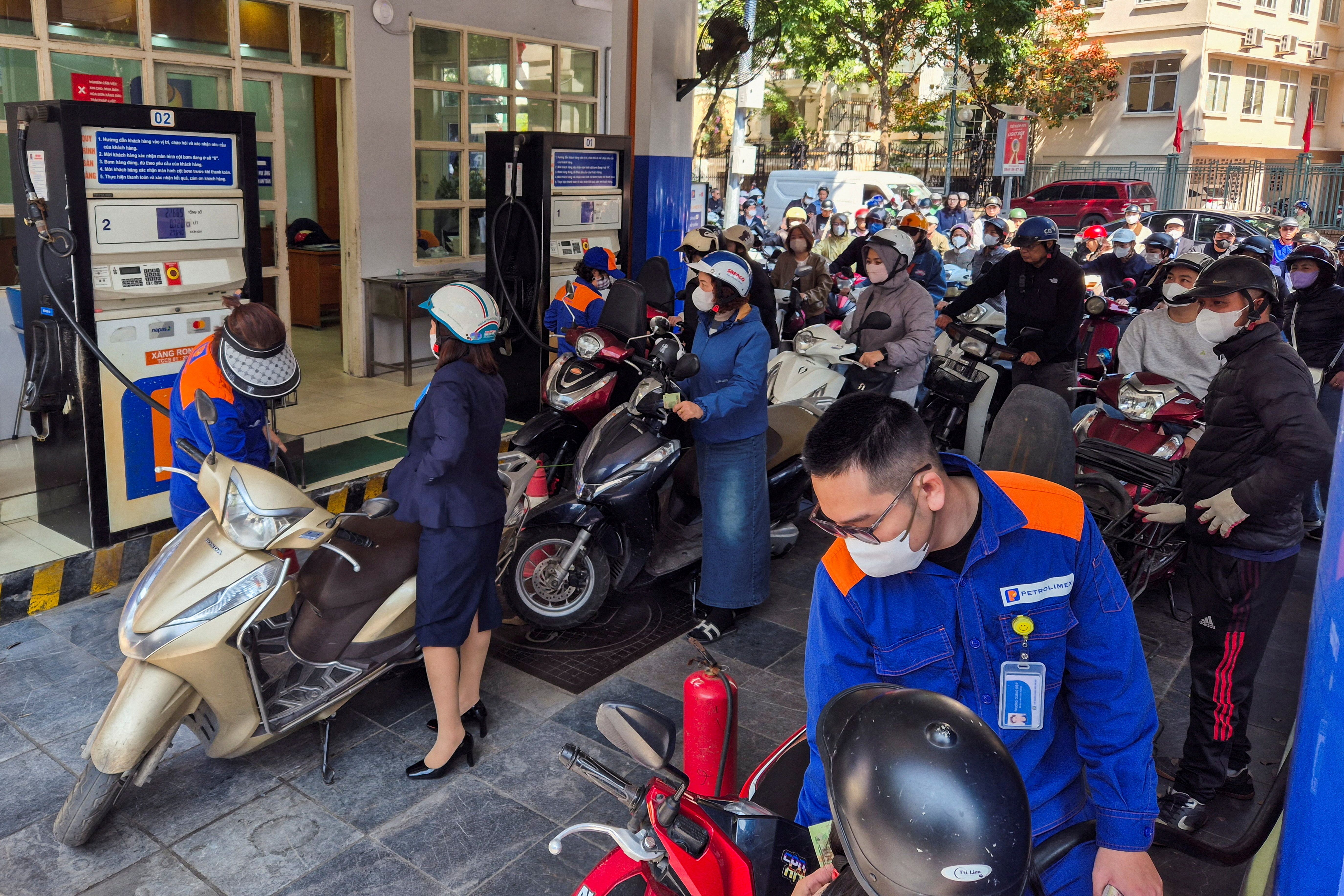 People queue to buy petrol at a petrol station in Vietnam.