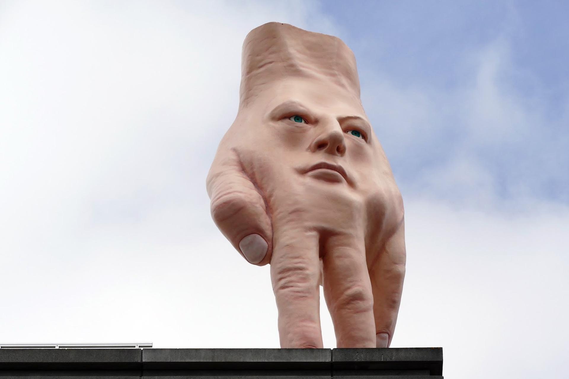 The hand statue with a face on it.