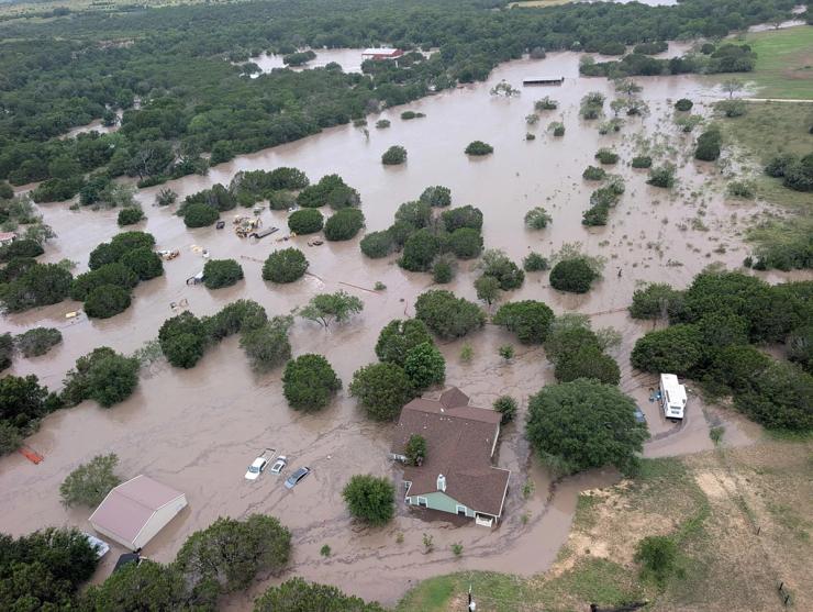 Houses and cars are partially submerged in flood waters.