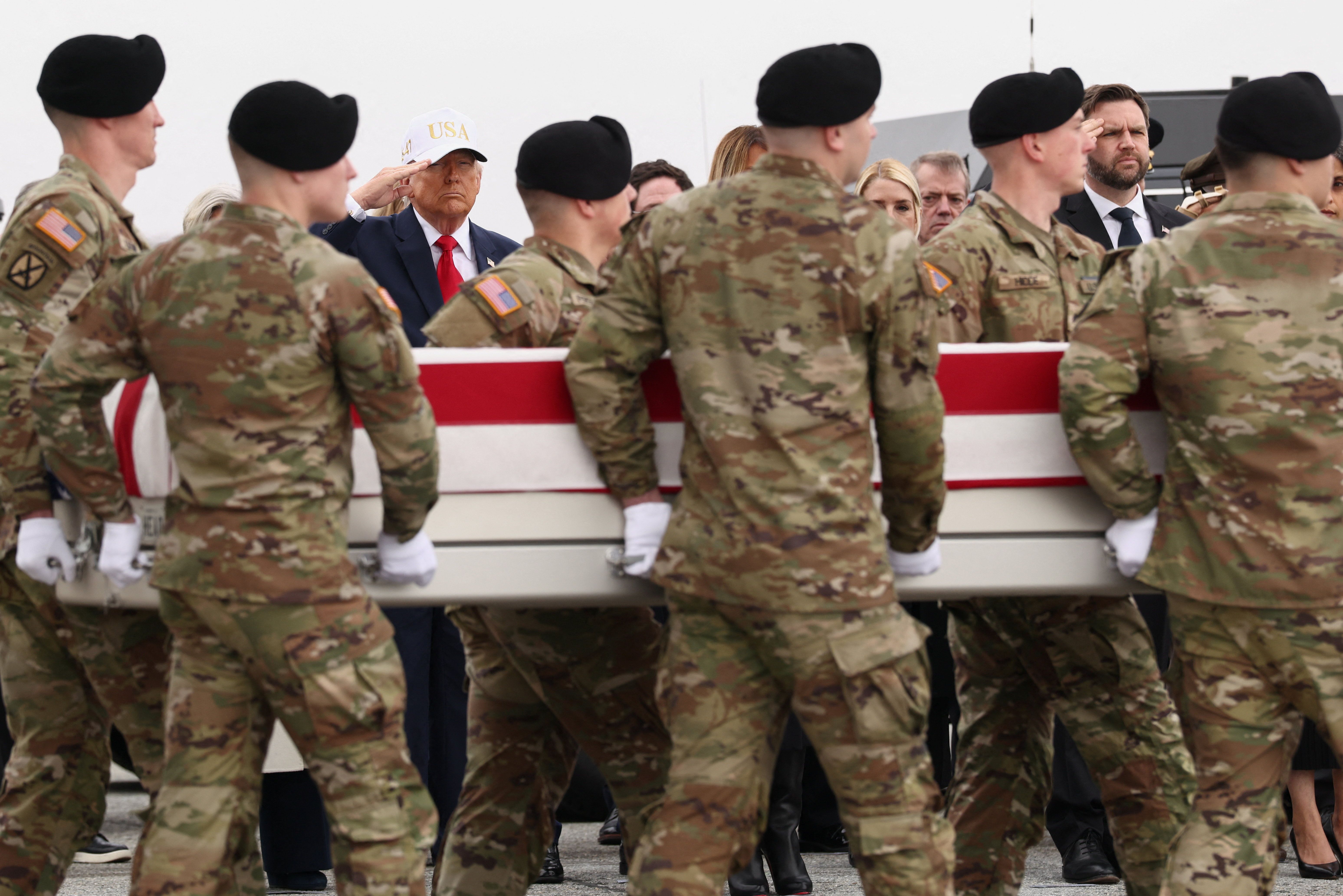 President Donald Trump and Vice President JD Vance salute as members of military carry a transfer case during a dignified transfer of the remains of six U.S. Army service members