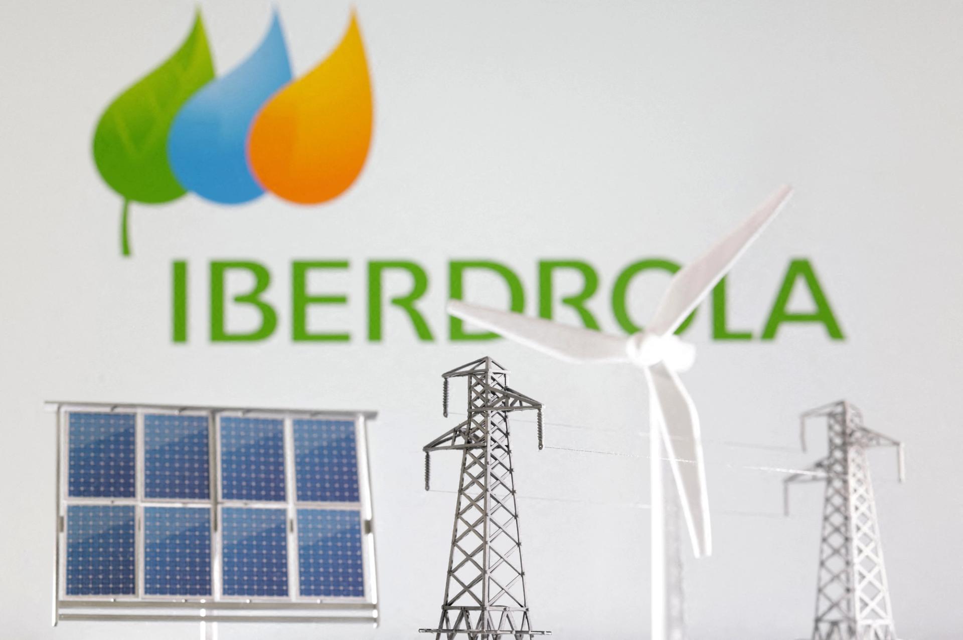 Miniatures of windmill, solar panel and electric pole are seen in front of Iberdrola Renewables logo in this illustration.